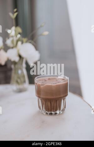 Glas kalte Schokoladenmilch auf einem weißen Marmortisch. Stockfoto