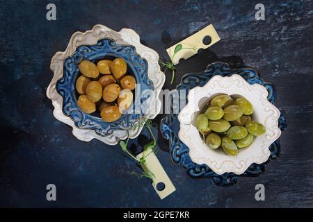 Zwei Arten von Oliven mit Käsescheiben und Mikrogemüse in Keramikplatten. Gesunde natürliche Nahrung. Ein starkes Antioxidans und gesundes Produkt. Oben vi Stockfoto