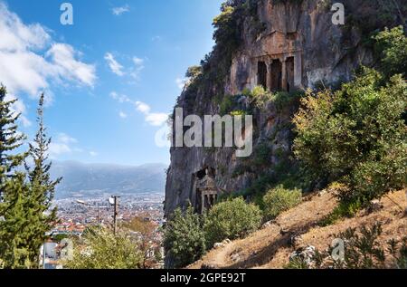 Uraltes lykischer Felsgrab in der antiken Stadt Telmessos auf einer Bergklippe. Blick vom Hügel in Fethiye, Stadt. Provinz Mugla, Türkei. Stockfoto