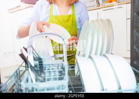 Nahaufnahme, Frau nimmt Geschirr aus der Spülmaschine Stockfoto