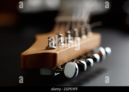 E-Gitarre, Nahaufnahme am Kopf, schwarzer Hintergrund, niemand. Streichmusikinstrument, Elektrosound, elektronische Musik, Ausrüstung für Bühnenconce Stockfoto