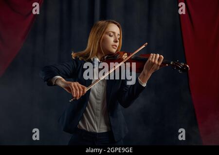 Violinistin mit Bogen und Violine, Solokonzert auf der Bühne. Frau mit Streichmusikinstrument, Musiker spielen auf Viola Stockfoto