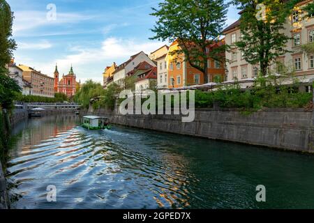 Ljubljana Stadtzentrum Tromostovje Brücke auf Ljubljanica Fluss in Slowenien Ljubjana mit Cerkev Marijinega oznanjenja Kirche mit Flussufer und eine Tour Stockfoto