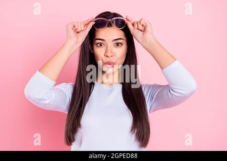 Portrait von attraktiven erstaunt Mädchen berühren specs News Reaktion Pout Lippen oops isoliert über rosa Pastellfarbe Hintergrund Stockfoto