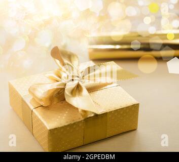 Geschenkbox mit Goldfolie, Band mit Schleife bedeckt. Stockfoto