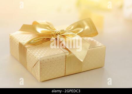 Geschenkbox mit Goldfolie, Band mit Schleife bedeckt. Stockfoto