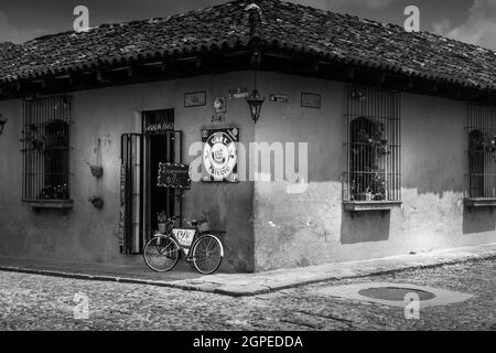 Schwarz-Weiß-Bild eines Eck-Shops mit einarmem Fahrrad an der Wand in Cartagena, Kolumbien, Südamerika. Keine Personen. Stockfoto