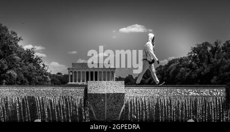 Schwarz-Weiß-Bild von einer einköpfigen Person in Weiß, die über den reflektierenden Pool-Wasserfall in Washington DC mit Blick auf das Lincoln-Denkmal läuft. Stockfoto