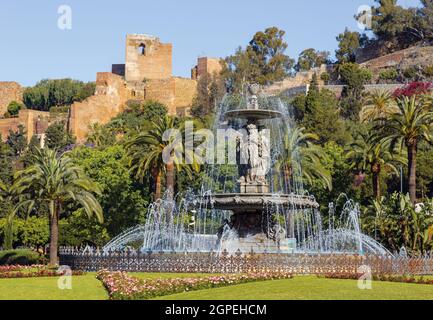 Brunnen der drei Grazien auch bekannt als die drei Nymphen auf der Plaza del General Torrijos mit der maurischen Alcazaba oder Festung dahinter. Malaga, Cos Stockfoto