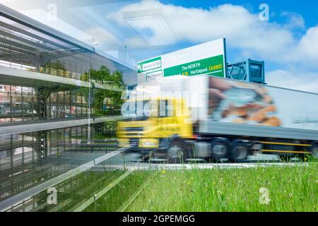 Leere Supermarktregale und LKW-Lastwagen auf der britischen Straße mit dem Schild „North on“. LKW-Fahrer, LKW-Fahrer Mangel Verbundkonzept. Stockfoto