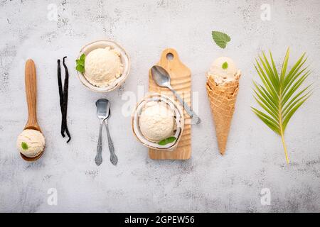 Kokoseis Aromen in der Hälfte der Kokosnuss Setup auf weißem Stein Hintergrund. Sommer und Süße Menükonzept. Stockfoto