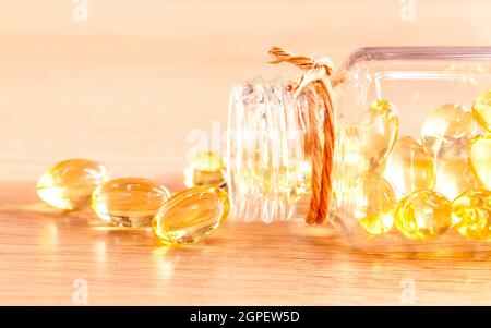 Dorschleber-Öl-Kapseln auf Holzplatte. Stockfoto