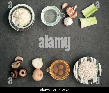 Italienische Lebensmittel Konzept und Design. Pilze risotto Zutaten auf dunklen rustikalen Stein Hintergrund mit Flach Platz und zu kopieren. Stockfoto