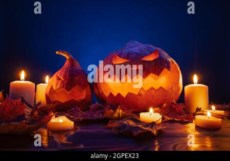 Zwei Kürbis-Laternen mit geschnitzten Gesichtern für die Halloween-Kerzenbeleuchtung. Stockfoto