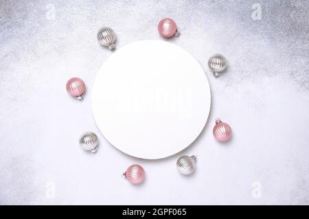 Weihnachtskomposition mit rosa und silbernen Kugeln. Weißes Papier, leere Kreisform. Weihnachtskarte. Flach liegend, Draufsicht, Kopierbereich - Bild Stockfoto