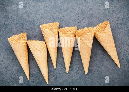 Flach Eistüten Sammlung auf dunklem Stein Hintergrund. Leere knusprige Eiswaffel mit Kopie Raum für Süßigkeiten Menü Design. Stockfoto