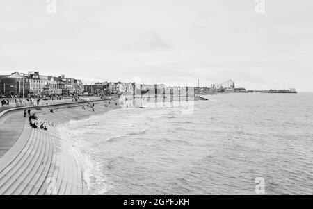 Touristen, die im September 2021 an der Südpromenade des Blackpool Beach in Schwarz-Weiß gesehen wurden. Stockfoto