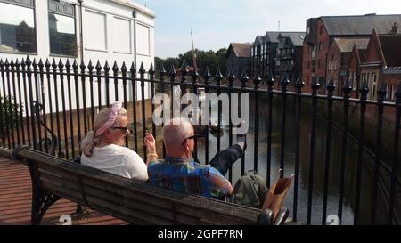 Ein Paar, das an der Brücke über den Fluss Ouse in der Cliffe High Street, Lewes, an einem sonnigen späten Septembernachmittag sitzt Stockfoto