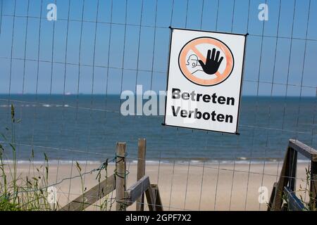 Abgedichteter Zugang zu Einem Strand. Kein Trespassing, Schild Mit Illustration, Im Hintergrund Der Strand Und Das Meer. Stockfoto