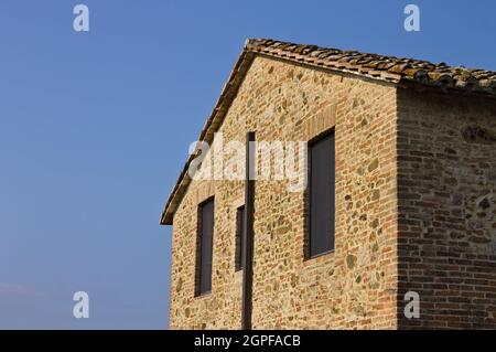 Die Fassade eines Bauernhaus aus Stein mit zwei Fenstern und einem Dach mit Fliesen bedeckt (Umbrien, Italien, Europa) Stockfoto