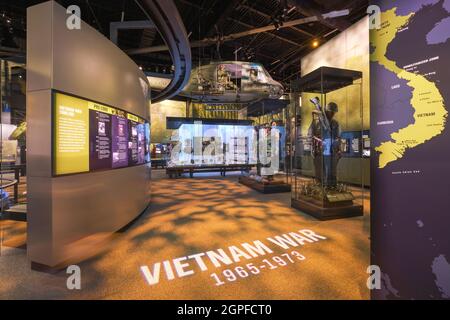 Ein Bell UH-1 Iroquois, Huey-Hubschrauber mit Schütze und verschiedene Soldatenuniformen in der Vietnam-Galerie, Raum. Im National Museum of the United Stat Stockfoto