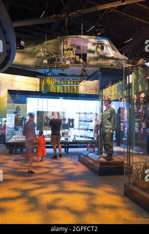 Ein Bell UH-1 Iroquois, Huey-Hubschrauber mit Schütze und verschiedene Soldatenuniformen in der Vietnam-Galerie, Raum. Im National Museum of the United Stat Stockfoto