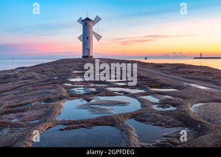 Ostsee und Stawa Mlyny, Navigationsleuchtfeuer in Form einer Windmühle bei Sonnenuntergang, offizielles Symbol von Swinoujscie, Polen Stockfoto