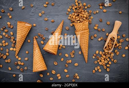 Flaches Kaffee-Eis in Waffelkegel auf dunklem Steinhintergrund. Hausgemachtes Kaffee-Eis mit Kaffeebohnen für Süßigkeiten Menüdesign. Stockfoto