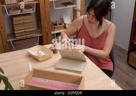 Junge Handwerkerin, die in ihrer Bio-Werkstatt arbeitet Stockfoto