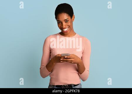 Porträt Einer Fröhlichen Schwarzen Jungen Dame Mit Smartphone In Den Händen Stockfoto