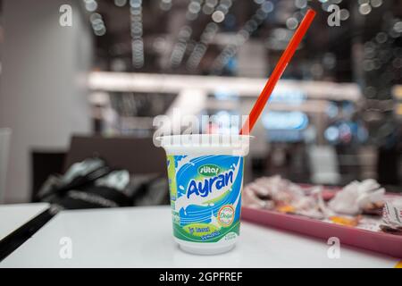 Sisli, Istanbul, Türkei - 07.13.2021: Selektiver Fokus von SUTAS Ayran-Plastikglas und Trinkhalmpipette auf einem Tisch vor verschwommener Menge Sh Stockfoto