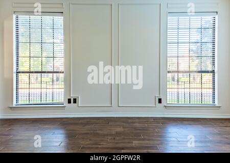 Leeres Wohnzimmer mit Holzfußboden und schräufigen weißen Wänden Stockfoto
