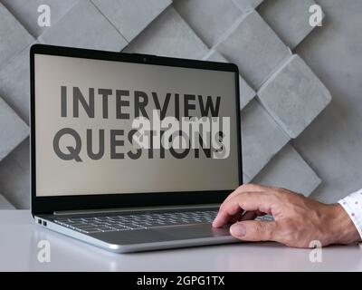 Der Mann liest Interviewfragen auf dem Laptop. Stockfoto