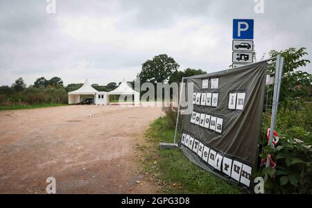 Timmendorfer Strand, Deutschland. September 2021. Ein Mitarbeiter führt in einem Drive-in-Testzentrum für Corona-Schnelltests in Hemmelsdorf bei Timmendorfer Strand einen Schnelltest an zwei Fahrzeuginsassen durch. Quelle: Christian Charisius/dpa - ACHTUNG: Kennzeichen wurde aus Datenschutzgründen verpixelt/dpa/Alamy Live News Stockfoto