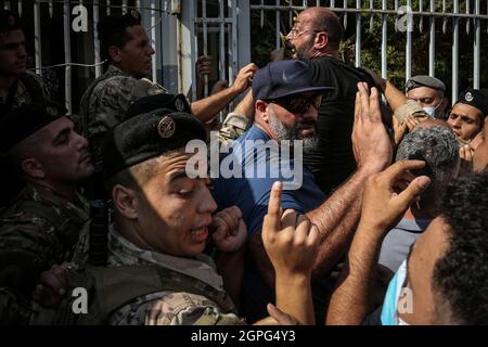 Beirut, Libanon. September 2021. Libanesische Demonstranten zerstochen mit Soldaten der Armee, während sie versuchen, das Justizministerium während einer Massendemonstration zu stürmen, um gegen die Aussetzung der Ermittlungen zur Hafenexplosion im letzten Jahr zu protestieren. Die Untersuchung der verheerenden Hafenexplosion in Beirut wurde am Montag ausgesetzt, nachdem ein Ex-Minister, der als Verdächtiger befragt wurde, eine Klage gegen den Ermittlungsrichter eingereicht hatte, sagten die Medien und eine gerichtliche Quelle. Quelle: Marwan Naamani/dpa/Alamy Live News Stockfoto