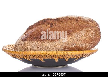 Ein Laib frisch gebackenes Buchweizenbrot in einer Keramikschale, aus der Nähe, isoliert auf Weiß. Stockfoto