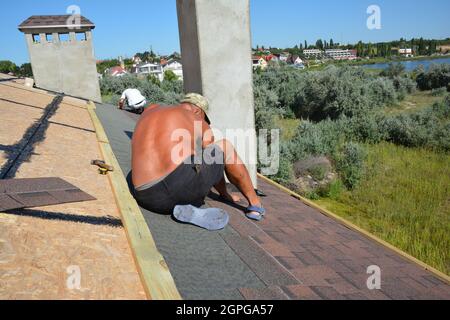 Dachdecker Verlegung Asphalt Schindeln Dach. Dachkonstruktion mit Dächern und Asphaltschindeln. Stockfoto