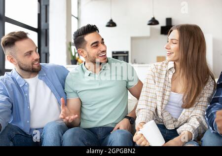 Inländische Partei. Gruppe von interracial Freunden verbringen Zeit zusammen zu Hause, Kaffee trinken, Unterhaltung zu haben Stockfoto