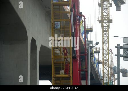 Jakarta, Indonesien. September 2021. Die Arbeiter gehen die Treppe hinunter, während einer Zeremonie zur Feier des Fertigstellens aller 24 durchgehenden Balken auf der Jakarta-Bandung High Speed Railway (HSR) in Bekasi, Provinz West Java, Indonesien, 29. September 2021. Der letzte durchgehende Strahl auf der Super-großen Brücke Nr. 2 der HSR Jakarta-Bandung wurde am Mittwoch erfolgreich geschlossen, was den Abschluss des Baus aller 24 durchgehenden Strahlen auf der Brücke markiert, teilte der Betreiber der Eisenbahn mit. Kredit: Zulkarnain/Xinhua/Alamy Live Nachrichten Stockfoto