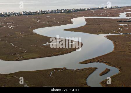 Luftaufnahme eines dünnen Streifens von Häusern, umgeben von Salzsumpfgebieten und dem Atlantischen Ozean, am Folly Beach, South Carolina, der lokal als The Edge of America bekannt ist. Stockfoto