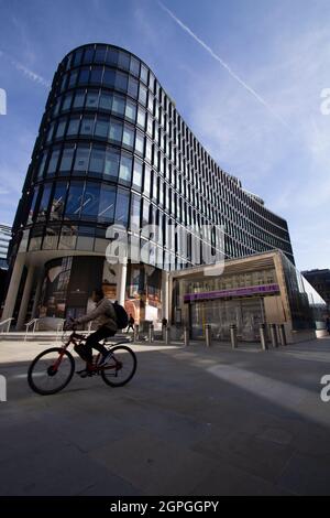 100 Liverpool Street Broadgate, London, Mieter u. a., Story, SMBC, BMO, Peel Hunt, RPMI, Milbank, SUMITOMO MITSUI BANKING CORPORATION, mit der geschlossenen Liverpool Street Station Eingang für die Liverpool Street Elizabeth Line Station, mit Radfahrer vorbei Stockfoto