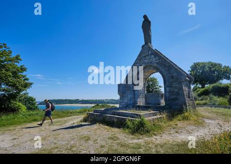 Frankreich, Cotes d'Armor, Cote d'Emeraude (Smaragdküste), Saint Cast le Guildo, Pointe de la Garde, Wanderer auf dem Wanderweg GR 34 oder dem Zollpfad, das Oratorium wird von einer Granitstatue gekrönt, die Notre-Dame du Guildo gewidmet ist Stockfoto