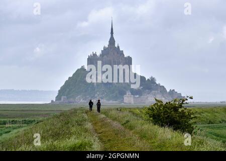 Frankreich, Manche, Mont Saint Michel Bay von der UNESCO zum Weltkulturerbe erklärt, Abtei von Mont Saint Michel, Wanderer zu Beginn der GR34 Stockfoto