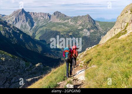 Frankreich, Haute-Savoie (74), Massif du Mont Blanc, les Contamines Montjoie, Refuge des Conscrits, Wanderer, die von links nach rechts zur Refuge de Tré-la-Tête (1969m) mit den Aiguilles de la Pennaz (2688m), dem Tête de la Cicle (2552m) und der Aiguille de Rosette (2384m) absteigen Stockfoto