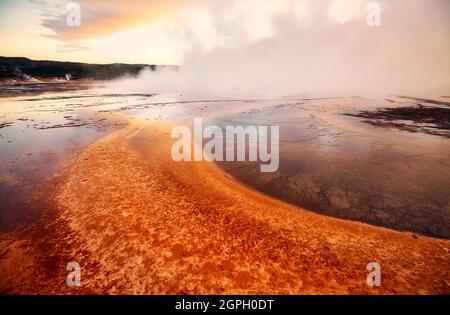 Sonnenuntergang über dem dampfenden Grand Prismatic Spring im Yellowstone National Park, Wyoming, USA. Stockfoto