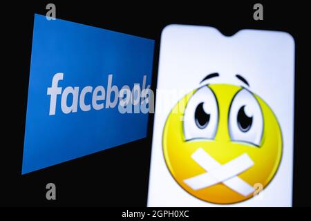 Das Foto zeigt den Einsatz von Zensur im sozialen Netzwerk facebook. Emojis mit aufgeklebtem Mund auf dem Hintergrund des Facebook-Logos. Stockfoto