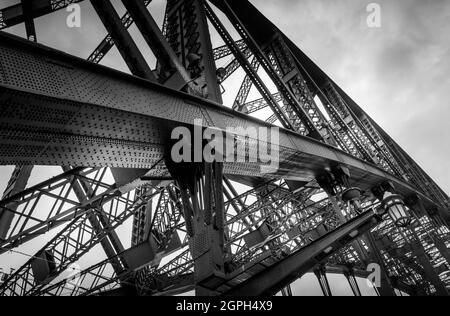 Schwarz-weißes Bild mit Details auf der Hafenbrücke von Sydney, das Struktur mit Nieten zeigt. Keine Personen. Stockfoto