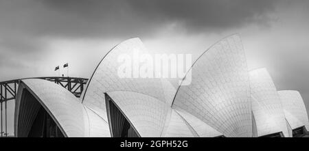 Monochromes Bild des Opernhauses von Sydney mit seinem Dach im Muscheldesign und einem Blick auf die Brücke. Keine Personen. Stockfoto