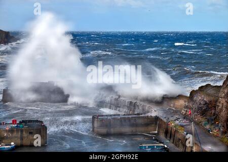 PORTKNOCKIE MORAY COAST SCOTLAND WINTERSTURM MIT WINDGETRIEBENEN WELLEN ÜBER DEN HAFENMAUERN Stockfoto