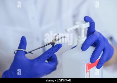 Der Arzt in Latexhandschuhen desinfiziert das medizinische Instrument Stockfoto